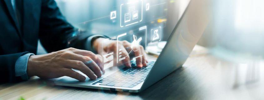 perche-parlare-di-odoo-gratis-ha-senso-per-una-pmi-manifatturiera Una persona vestita elegantemente sta lavorando su un computer portatile.