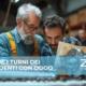 Tre uomini lavorano su una macchina in una fabbrica, concentrati sulle loro attività.